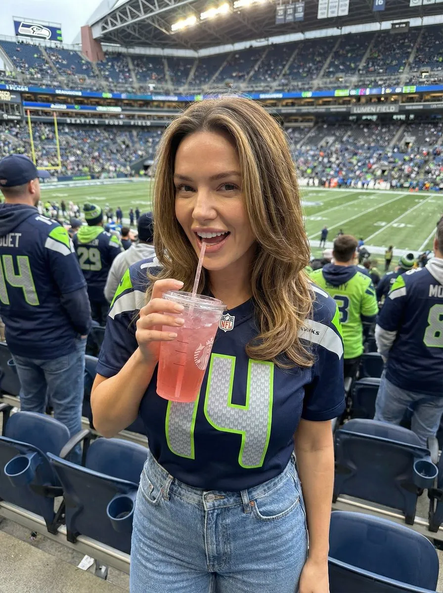 Промпт задаёт сцену матча Seahawks с розовым напитком и шумной толпой. · пример 2