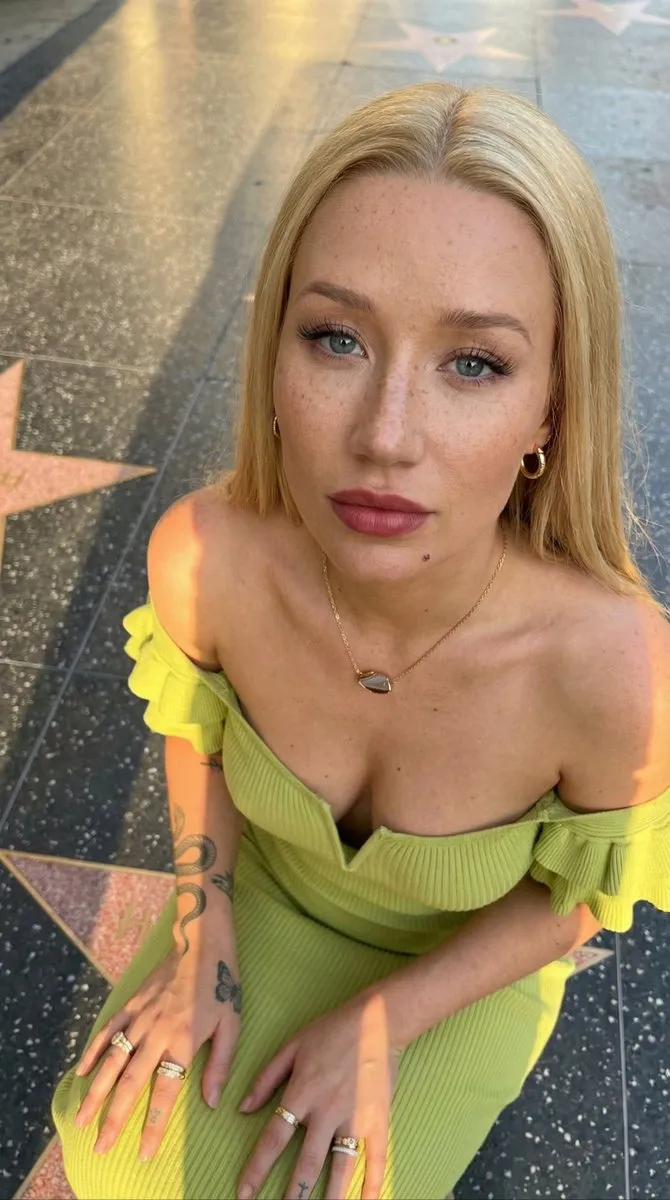 Iggy Azalea сидит на Аллее славы и смотрит вверх в камеру. · пример 2