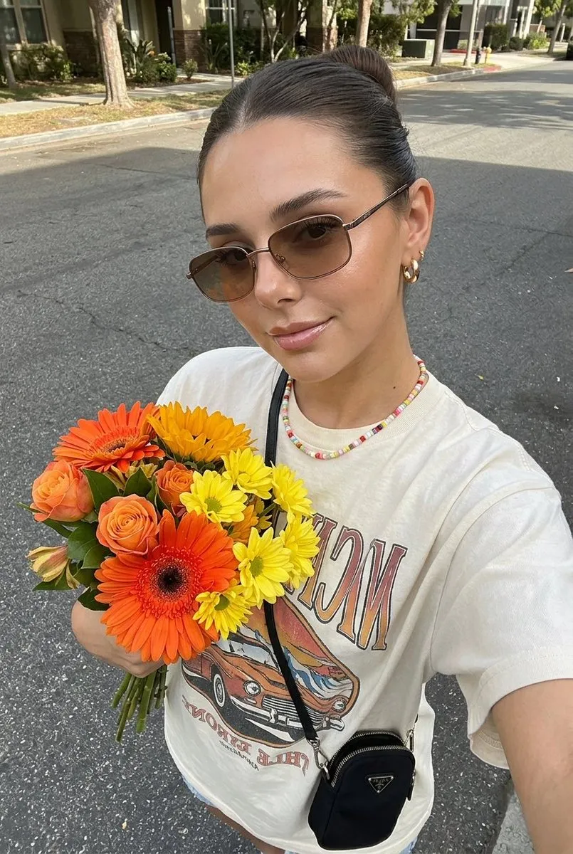 Пример уличного селфи молодой женщины с букетом оранжевых и жёлтых цветов. · пример 4