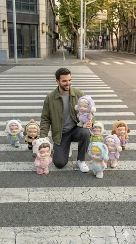 Молодой мужчина идёт по пешеходному переходу, вокруг него расположены фигурки Popmart Skullpanda.