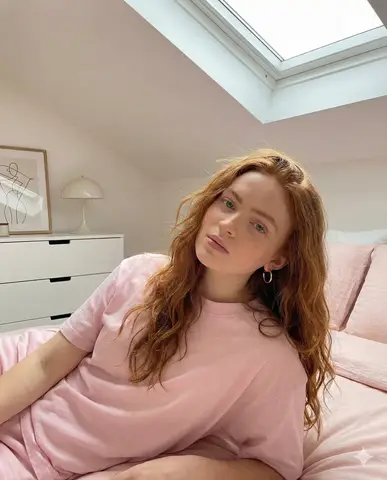 Промпт для редакционного портрета Sadie Sink с рыжими волнами и розовым акцентом в одежде.