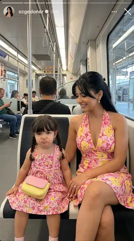 Мама и дочь сидят вместе в поезде Marmaray; сверху добавлен интерфейс Instagram Story.